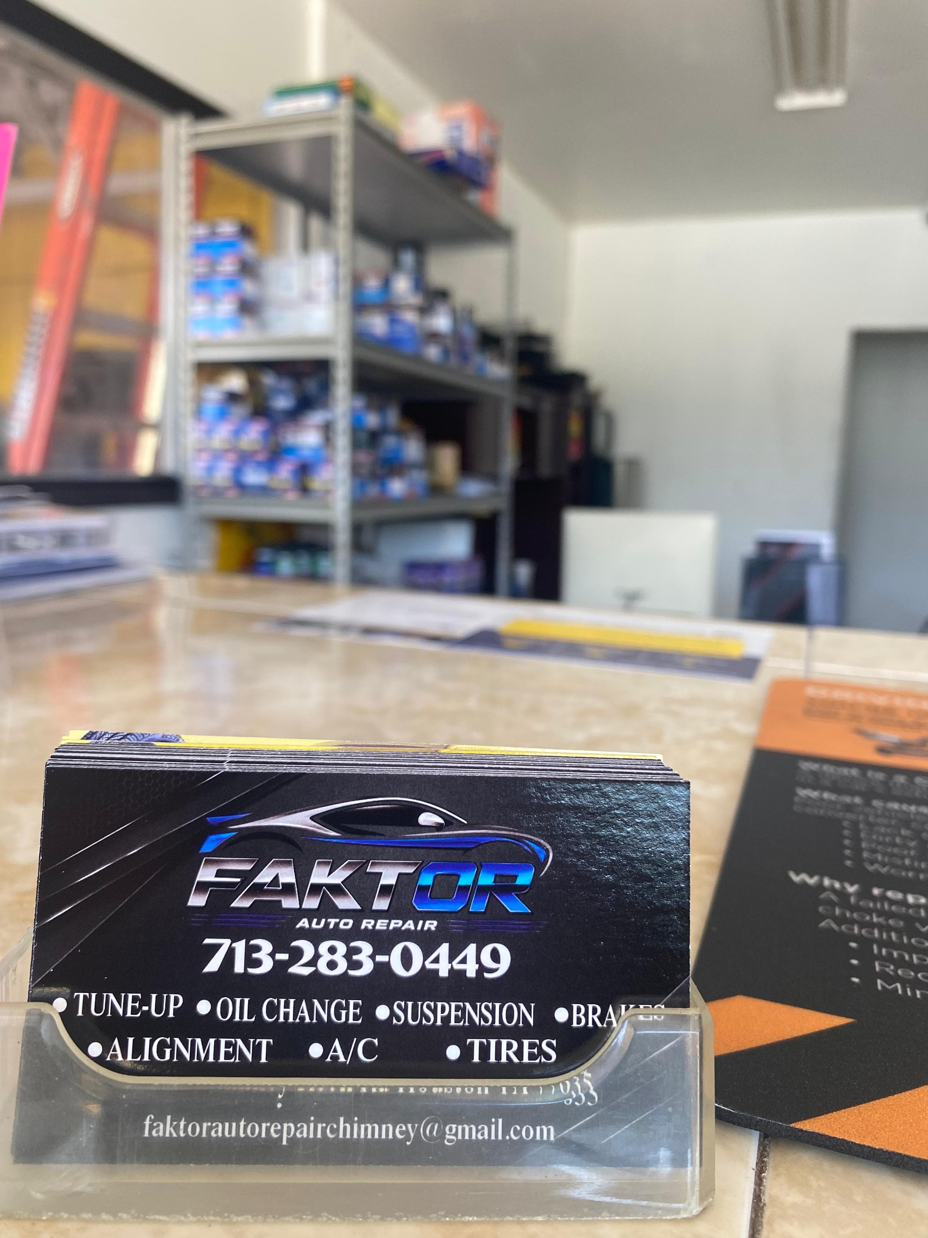 Tarjeta de presentación de Faktor Auto Repair sobre el mostrador del taller